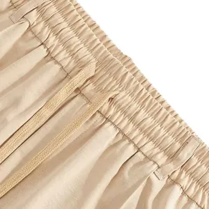 Dettaglio dell'elastico in vita e del cordoncino regolabile sui pantaloni sportivi beige