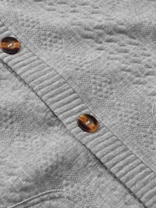 Close-up detail of vintage amber buttons and jacquard texture on grey men's cardigan