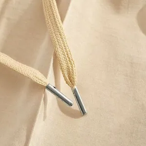 Dettaglio del cordoncino beige per pantaloni sportivi da uomo con punte in metallo argento