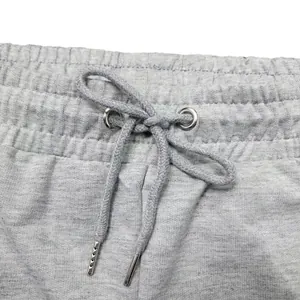 Primer plano de la cintura de pantalones deportivos grises con cordón y puntas metálicas