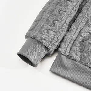 Macro view of grey jacquard fleece sweatshirt showing ribbed cuffs and hem textures