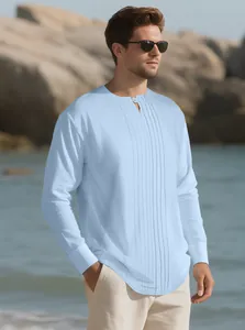 Light blue pleated linen Henley shirt for men on a beach background.