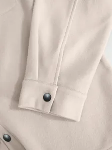 Detailansicht der Ärmelmanschette einer beigen Herren-Wolljacke mit Druckknopf