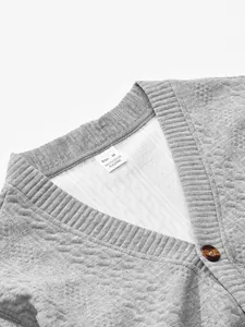 Close-up detail of the grey V-neck cardigan showing fabric texture and care label