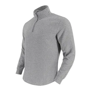 Détail du motif à carreaux jacquard gris sur un sweat-shirt à col montant pour homme.