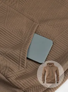 Vue détaillée montrant la poche fonctionnelle d'un sweat à capuche jacquard marron pour homme.