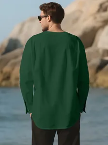 Back view of a men's dark green long sleeve linen Henley shirt at the beach