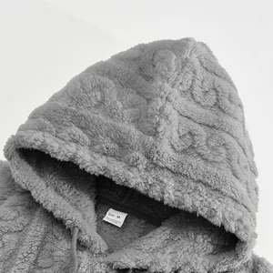 Detailed close-up of grey jacquard fleece hoodie showing soft fabric texture and size label
