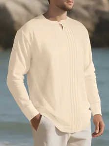 Detail of the pleated front design on a cream long-sleeve linen Henley shirt for men