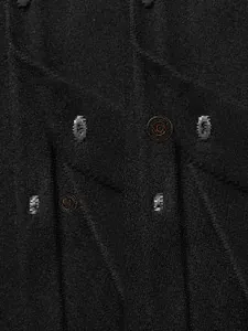 Detaillierte Nahaufnahme einer schwarzen Wolljacke mit strukturiertem Stoff und Knöpfen