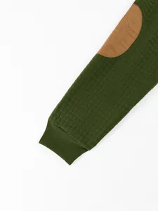 Close-up of green waffle knit sleeve with brown elbow patch and ribbed cuff detail