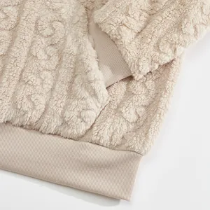 Detailed texture of beige jacquard sherpa fleece fabric on ribbed hem and cuff