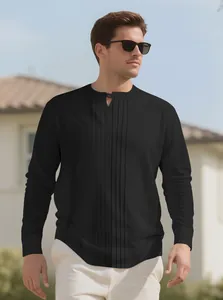 Close-up of black pleated henley shirt with linen texture on male model outdoors.