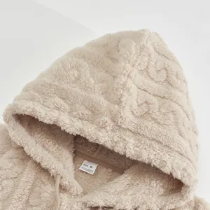Close-up of beige jacquard fleece hoodie showing soft texture and size M label detail