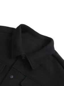 Detailaufnahme des Kragens und der matten Knöpfe einer schwarzen Wolljacke für Herren