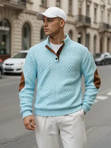 Dettaglio della trama jacquard a rombi e toppe marroni sui gomiti di un maglione in maglia blu