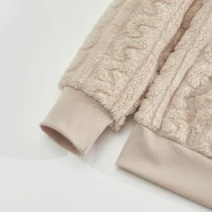 Close-up of the ribbed cuffs and soft jacquard fleece texture on a beige sweatshirt