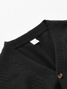 Detail shot of men's black V-neck cardigan with jacquard texture and fabric tag