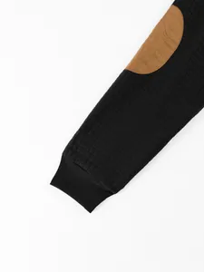 Detailed close-up of quilted sleeve with brown elbow patch on a black men's sweatshirt.