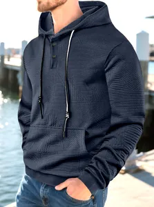 Gros plan détaillé d'un sweat à capuche jacquard bleu marine pour homme avec col à boutons.