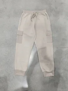 Dettaglio dei pantaloni jogger cargo beige con trama jacquard a quadretti moda