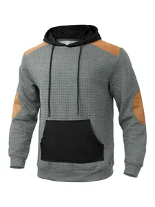 Detailed view of gray quilted men's hoodie with black pocket and brown patches