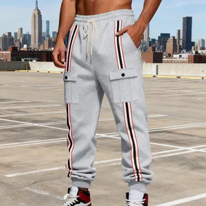 Primo piano di pantaloni sportivi grigi da uomo con strisce e tasche laterali.