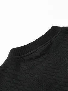 Close-up of black diamond jacquard fabric and ribbed neckline on a men's knit cardigan