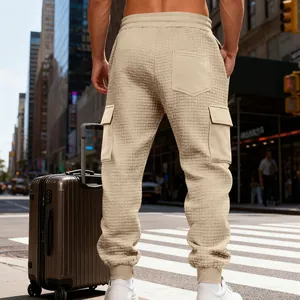 Dettaglio di pantaloni cargo beige da uomo in tessuto waffle con tasche multiple in città