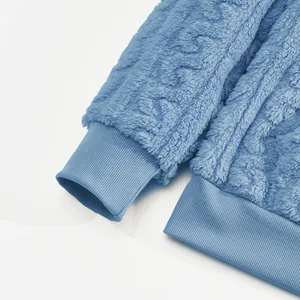 Detail view of ribbed cuffs and elastic hem on a blue fuzzy fleece hoodie for men.