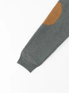 Close-up detail of grey waffle fabric sleeve featuring a brown elbow patch and ribbed cuff