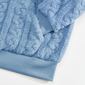 Detail of light blue jacquard fleece hoodie showing ribbed cuff and soft texture