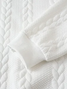 Dettaglio del tessuto jacquard bianco sulla manica di una felpa di alta qualità