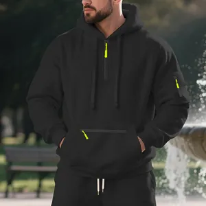 Détail d'un sweat à capuche en polaire noir pour homme avec des fermetures éclair jaune néon