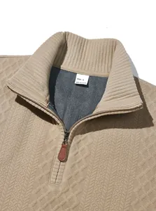 Close-up of heavy jacquard fabric texture and half-zip collar on men's tan sweater