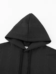 Close-up of black heavyweight jacquard hoodie with detailed knit texture and size tag