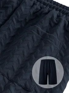 Detail view of dark navy men's shorts showing textured jacquard zigzag fabric pattern.
