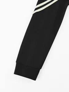 Close-up of black men's hoodie sleeve featuring a jacquard braided pattern and cuff.