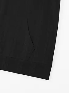 Close-up of the black cable-knit jacquard texture on a heavy hoodie with front pocket