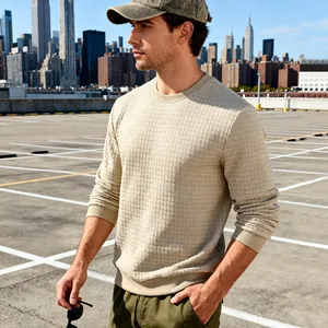 Nahaufnahme eines beigen Herren-Sweatshirts mit Waffelstruktur auf einem städtischen Dach