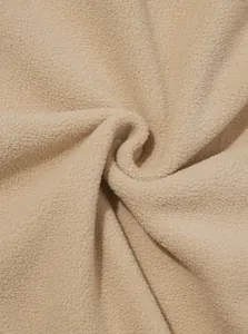 Nahaufnahme der weichen beigen Polar-Fleece-Textur für dicke Herren-Winterpullover.
