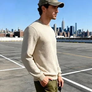 Nahaufnahme von cremefarbenem Herren-Sweatshirt mit Waffelstruktur in urbaner Kulisse