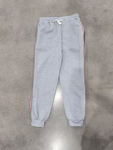 Vista completa dei pantaloni della tuta grigi con strisce laterali rosse e nere