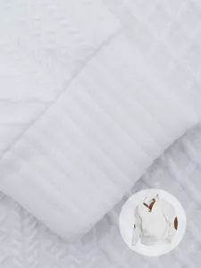 Dettaglio ravvicinato della trama in maglia jacquard bianca e polsino a coste della camicia