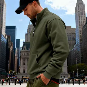 Herren Sweatshirt mit halbem Reißverschluss in Olivgrün vor einer modernen Stadtkulisse