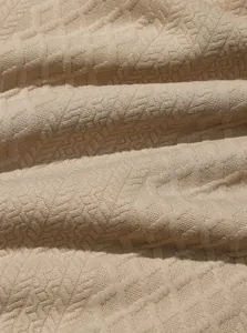 Macro view showing the intricate heavy jacquard woven texture of a men's sweatshirt.