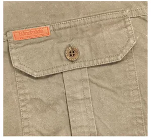Vue macro détaillée de la poche d'une chemise de travail kaki avec bouton et étiquette