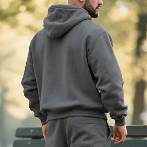 Vue arrière d'un homme portant un sweat à capuche gris foncé épais dans un parc