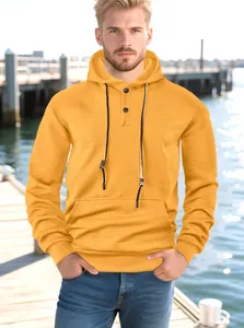 Détail d'un sweat à capuche jaune pour hommes en jacquard avec boutons et poche kangourou