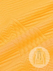Détail macro de la texture du tissu jacquard jaune en zigzag sur un sweat à capuche
